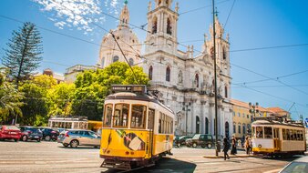 Gelbe Straßenbahnen vor der Basilica de Estrela in Lissabon