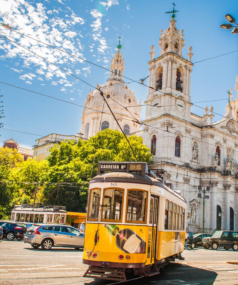 Gelbe Straßenbahnen vor der Basilica de Estrela in Lissabon